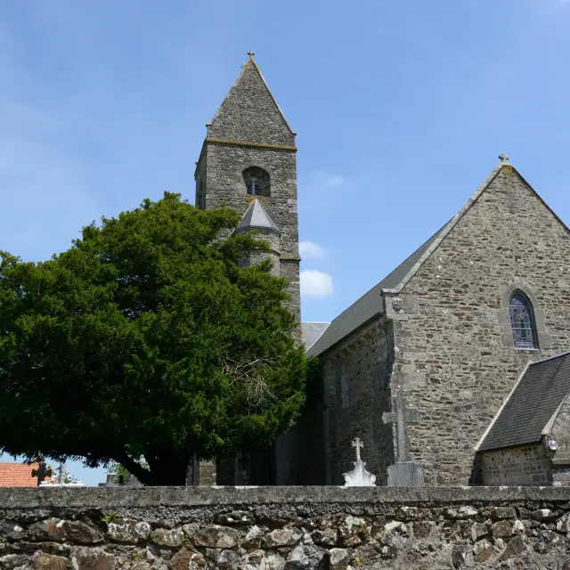 Stone church with a bell tower and a tree on the left