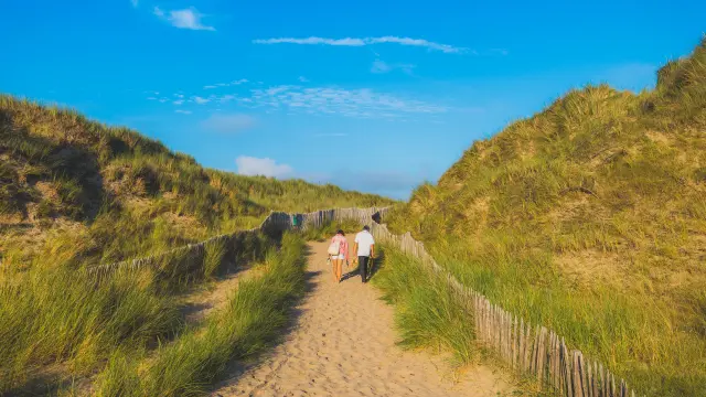 Deux personnes marchant dans les dunes de Annoville