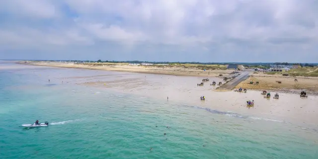 Feiner Sandstrand mit türkisfarbenem Wasser und einigen Menschen