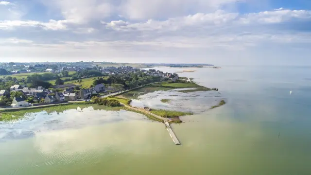 Aerial view of a coastal village with houses and farmland