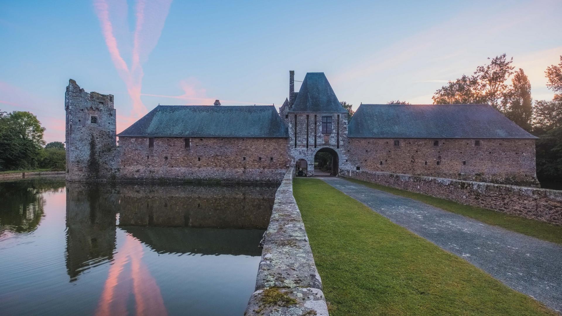 Château de Gratot avec douves au coucher du soleil