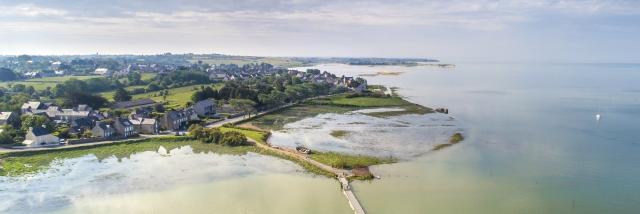 Aerial view of a coastal village with houses and farmland