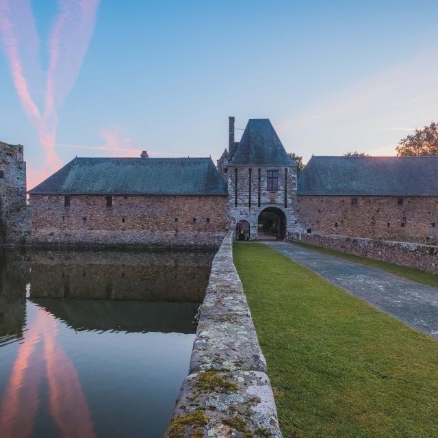 Château de Gratot avec douves et pont-levis au coucher du soleil