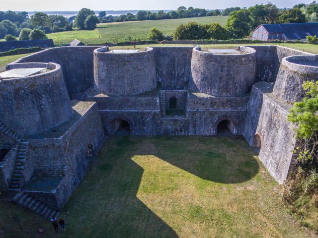 Aerial view of a stone fortress with thick walls and round towers