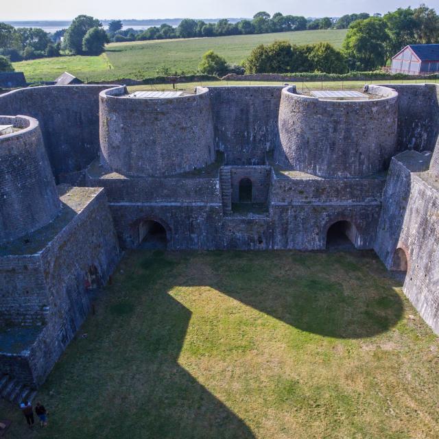 Vue aérienne d'une forteresse en pierre avec des murs épais et des tours rondes