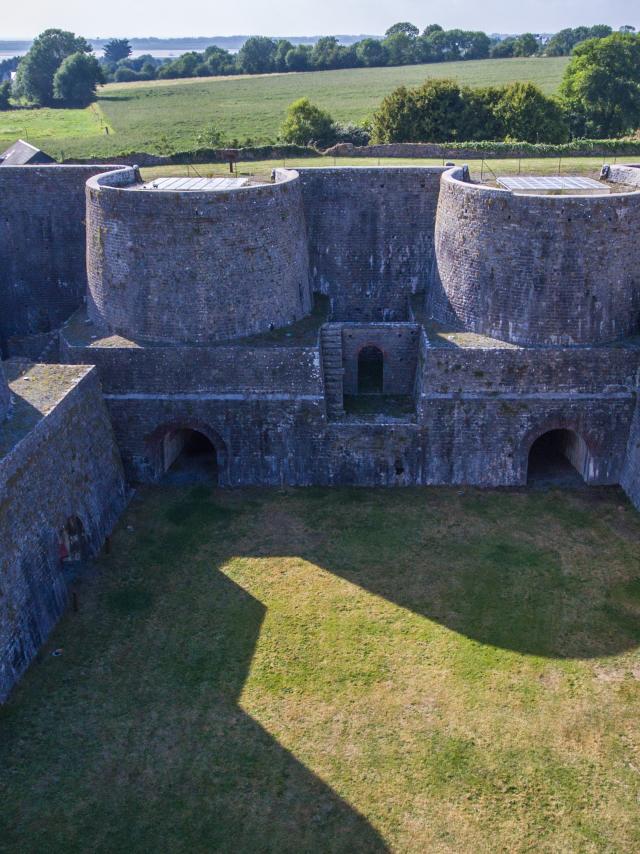 Aerial view of a stone fortress with thick walls and round towers