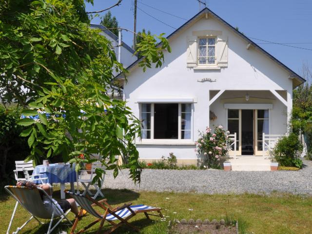 White house with garden and lounge chairs