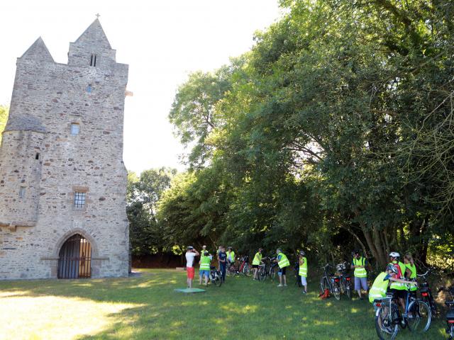 Group of cyclists in front of a medieval tower