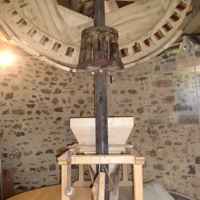 Wooden oil mill with a suspended grinding stone and a crushing mechanism