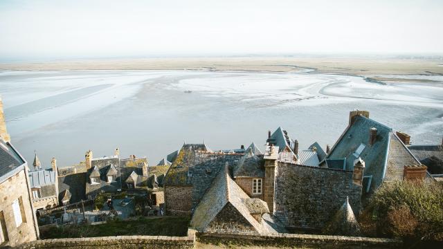 Aerial view of a coastal village with stone houses and a water expanse