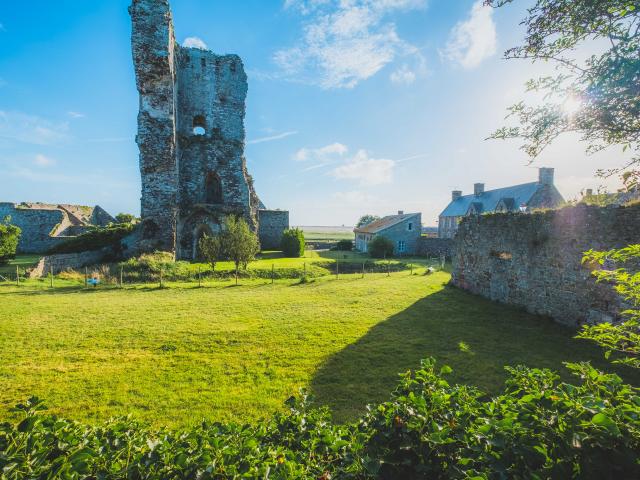 Ruins of a medieval castle with modern buildings nearby