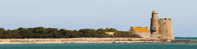 Isolated coastal fortress with a yellow roof and stone walls