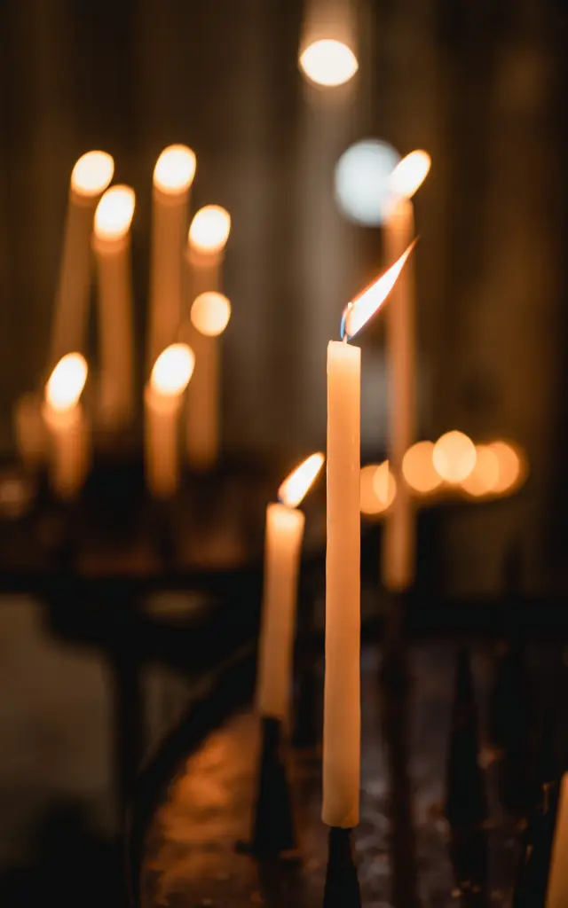 Plusieurs bougies allumées dans un lieu sombre
