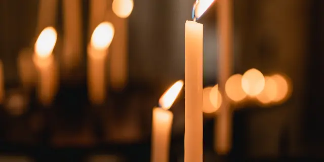 Plusieurs bougies allumées dans un lieu sombre