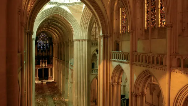 View of the interior of a cathedral with arches and stained glass