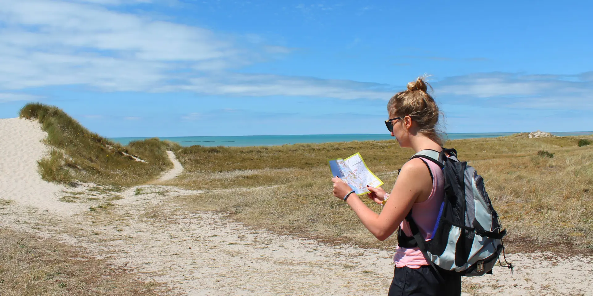 A woman hiking looks at a map outdoors