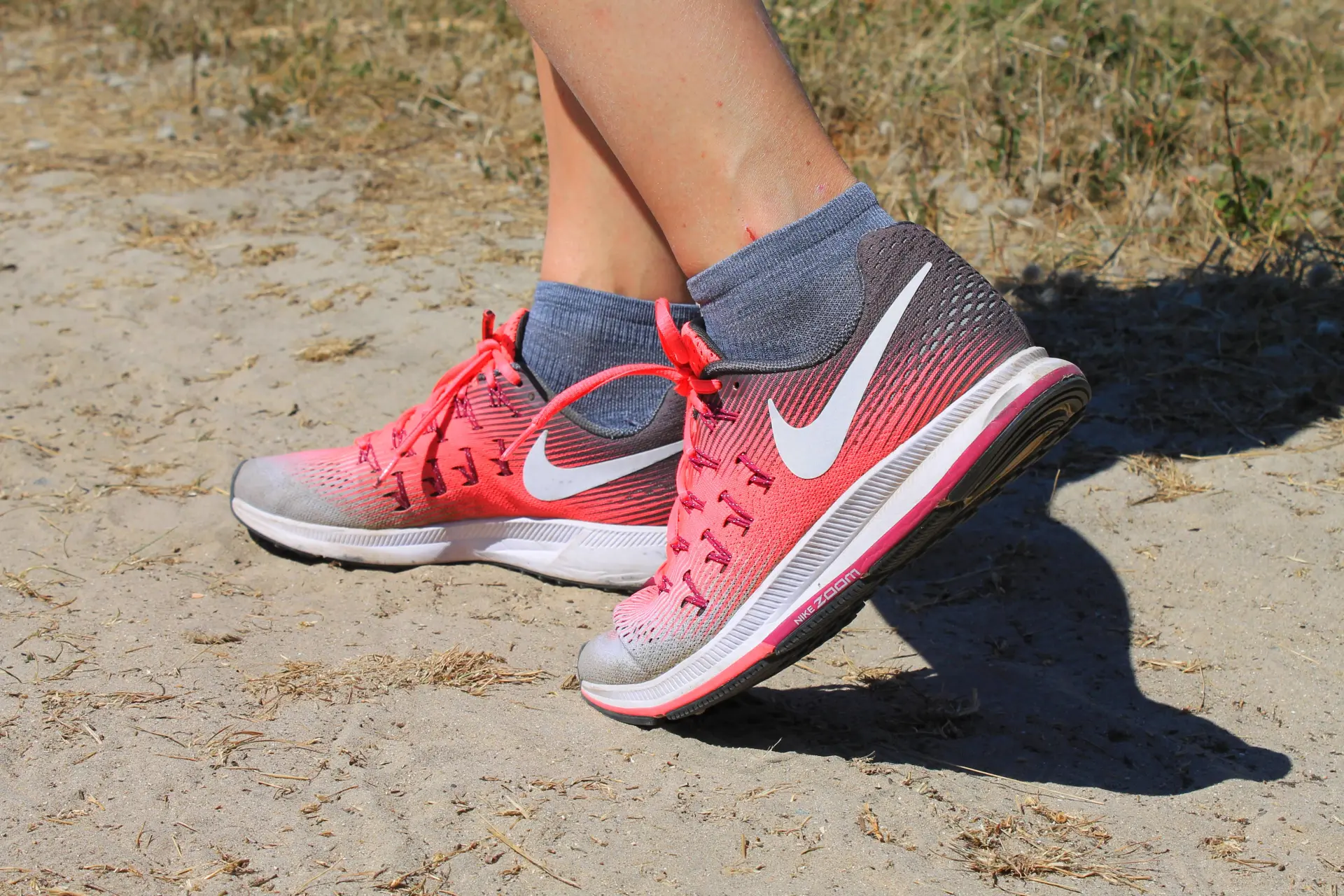 Pieds portant des chaussures de sport rouges et grises avec des chaussettes grises