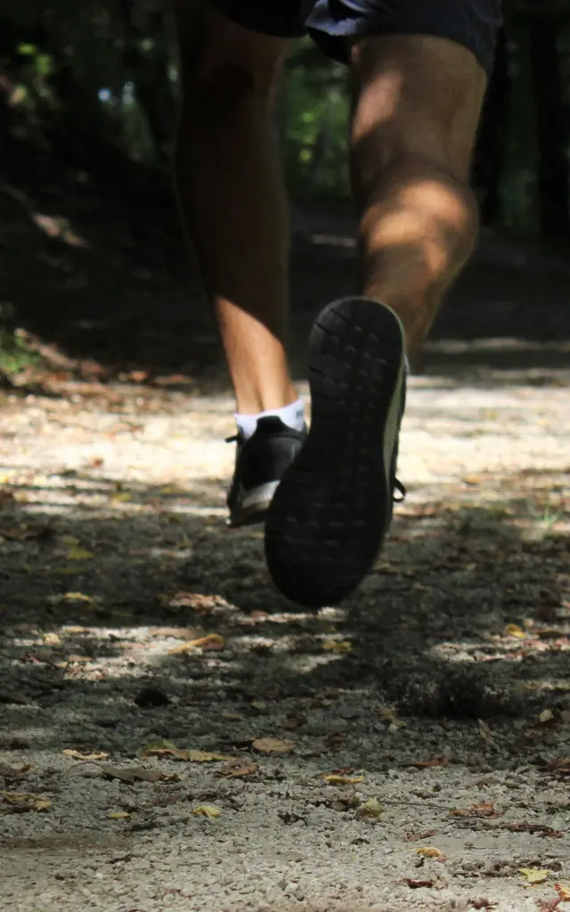 Pieds d'un coureur en mouvement sur un sentier forestier
