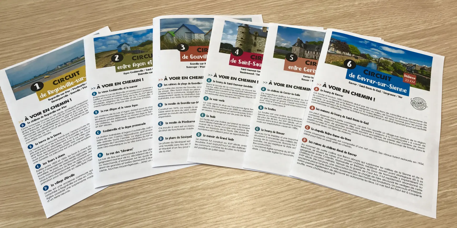 Six tourist brochures in French on a wooden table