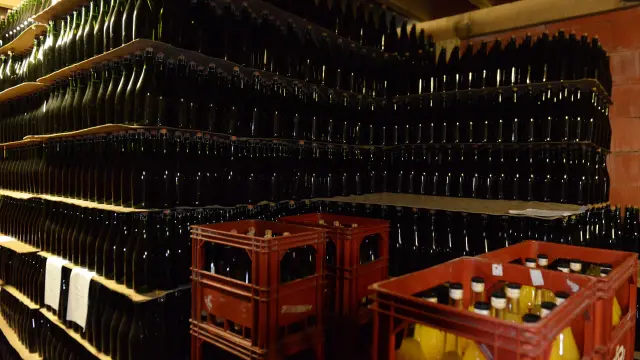 Rayonnages remplis de bouteilles de cidre et de caisses de bouteilles