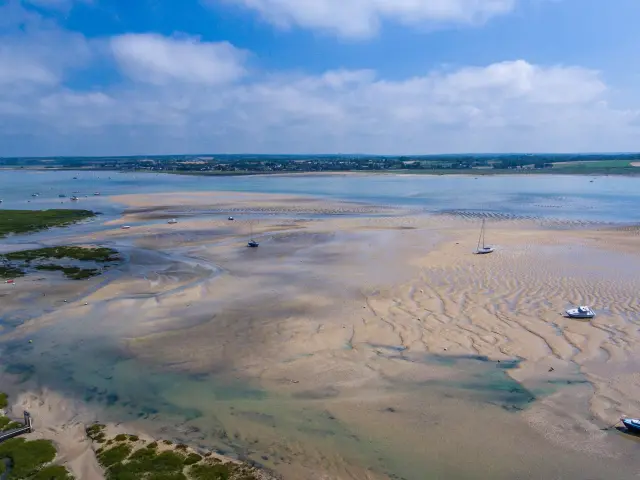 Beach with boats stranded at low tide