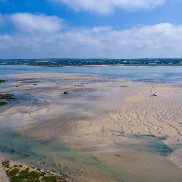 Beach with boats stranded at low tide