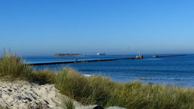 Lighthouse at the end of a pier extending into the ocean