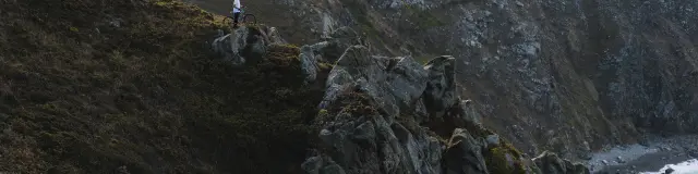 Zwei personen, die auf einem felsigen weg am meer spazieren gehen