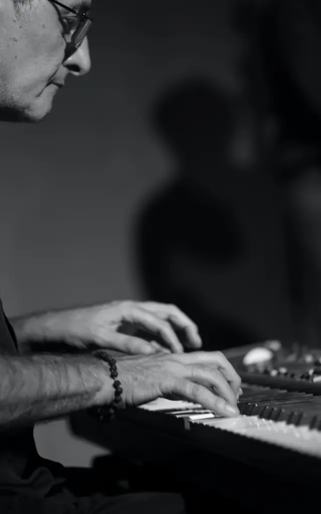 Un homme jouant du piano avec des lunettes et un bracelet