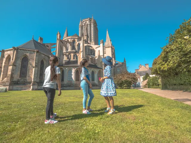 Trois personnes devant la cathédrale de Coutances