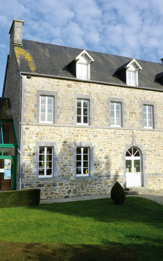 Large stone house with a well-maintained garden