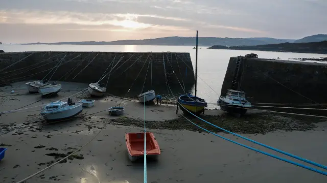 Fishing boats moored in a harbor at sunset