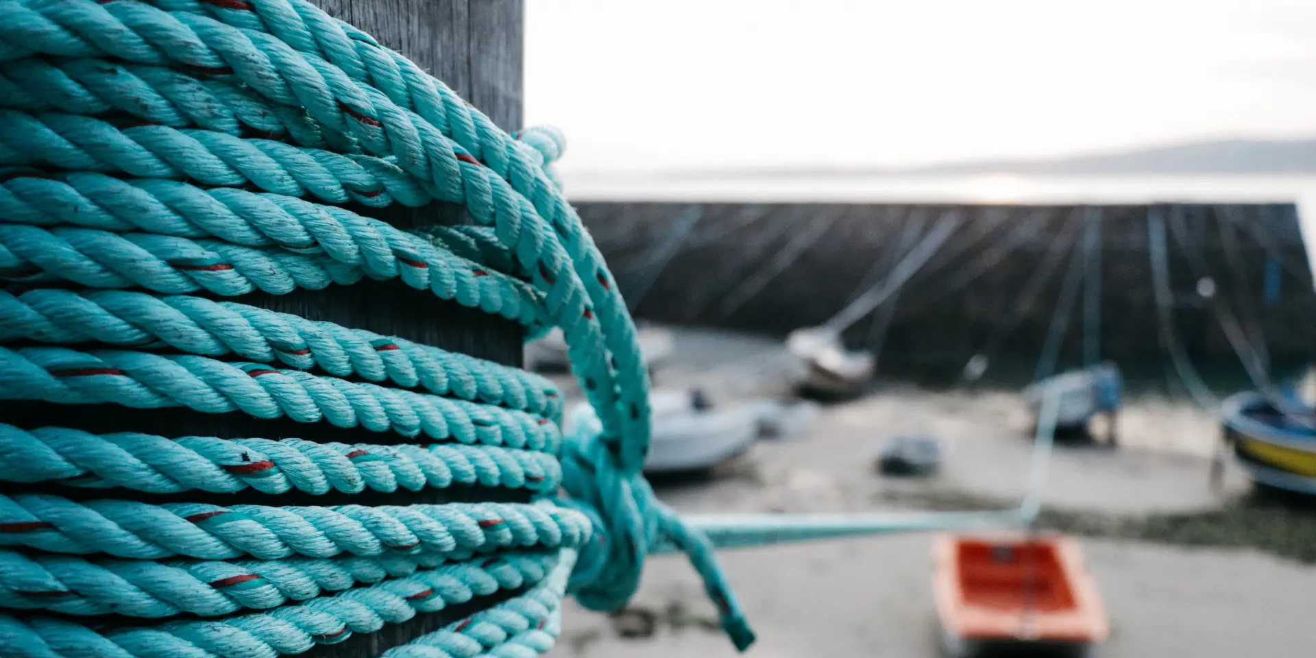 Close-up of a blue rope coiled around a post on a dock