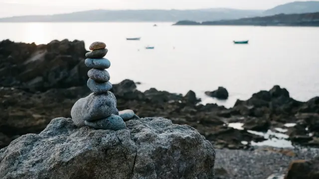 A stack of balanced stones on a rock by the sea
