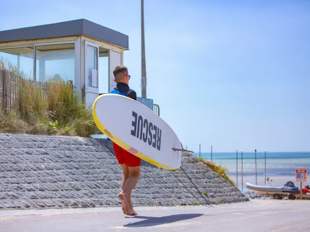 Sauveteur et sa planche sur la plage de Hauteville sur Mer