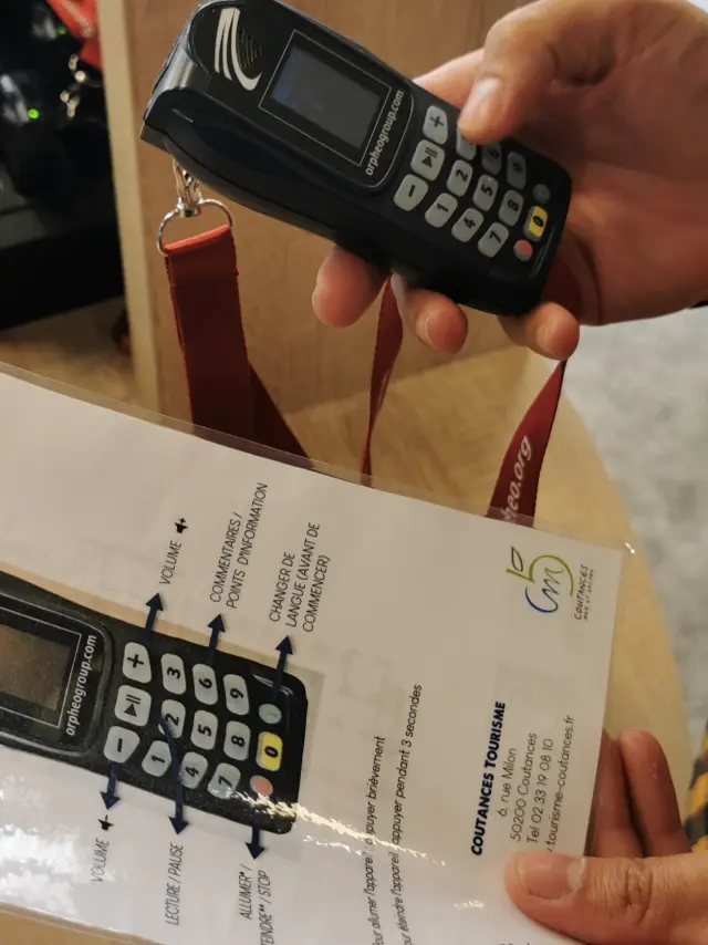 Eine Person hält ein Mobiltelefon und eine Bedienungsanleitung
