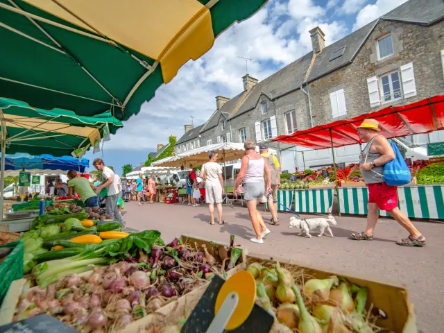 Personnes faisant leurs courses dans un marché avec des parasols colorés