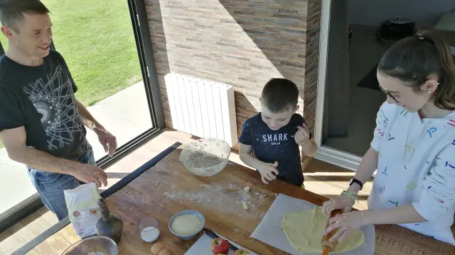 Trois personnes préparant de la pâte à tarte sur une table en bois