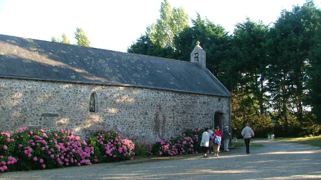 Stone chapel with pink flowering bushes outside