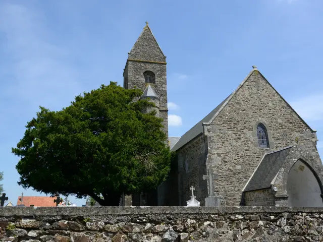 Stone church with a bell tower and a tree on the left