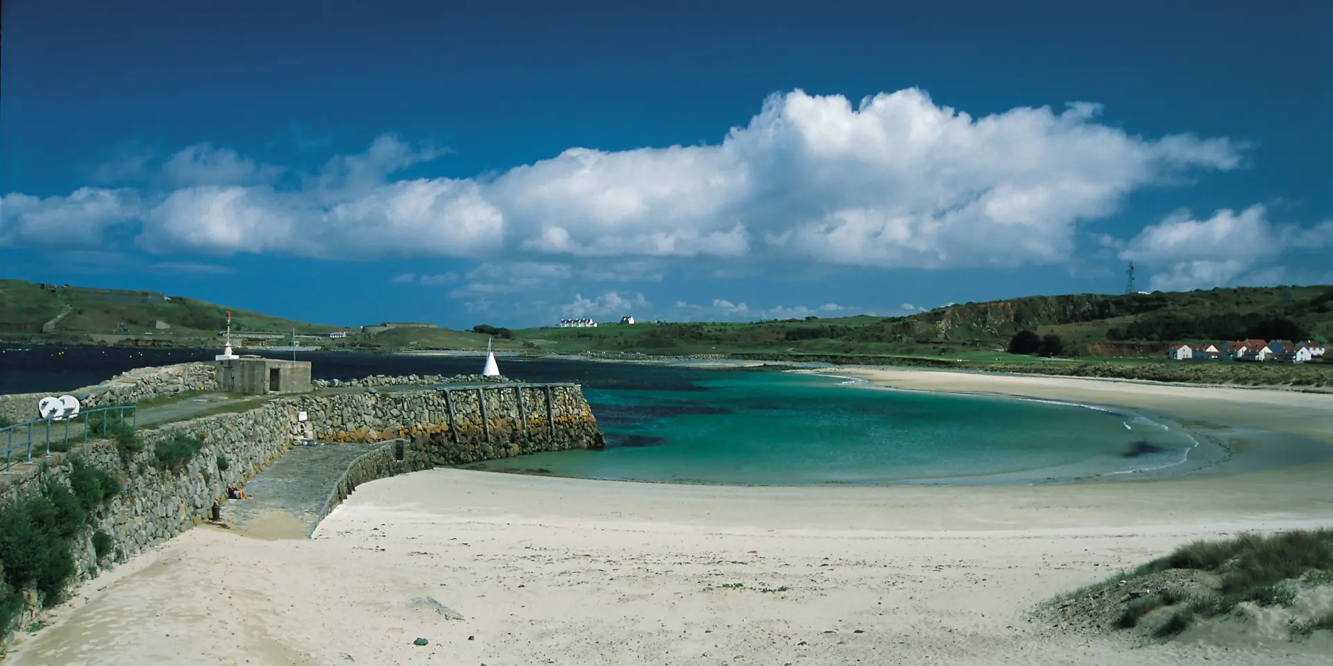Weißer Sandstrand mit türkisfarbenem Wasser und einem klaren blauen Himmel