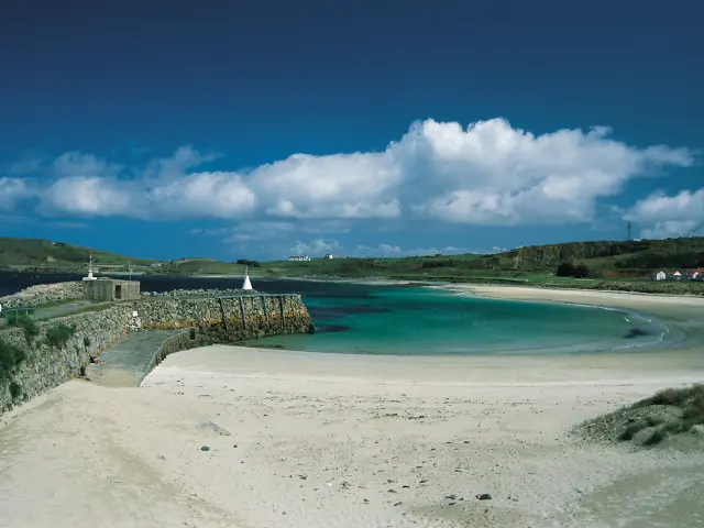 Weißer Sandstrand mit türkisfarbenem Wasser und einem klaren blauen Himmel