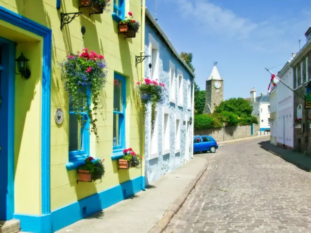 Cobblestone street with colorful houses and hanging flowers