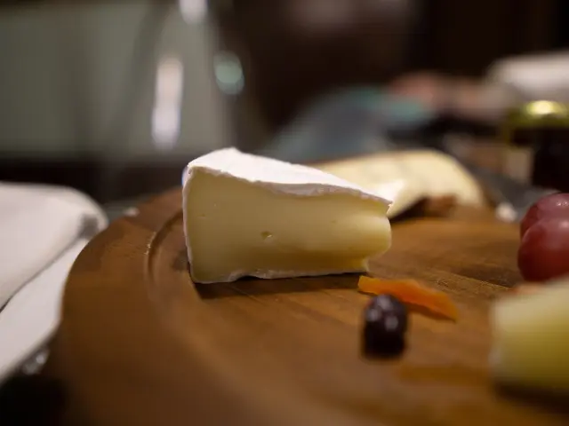 Wooden platter with cheese, grapes, and carrots