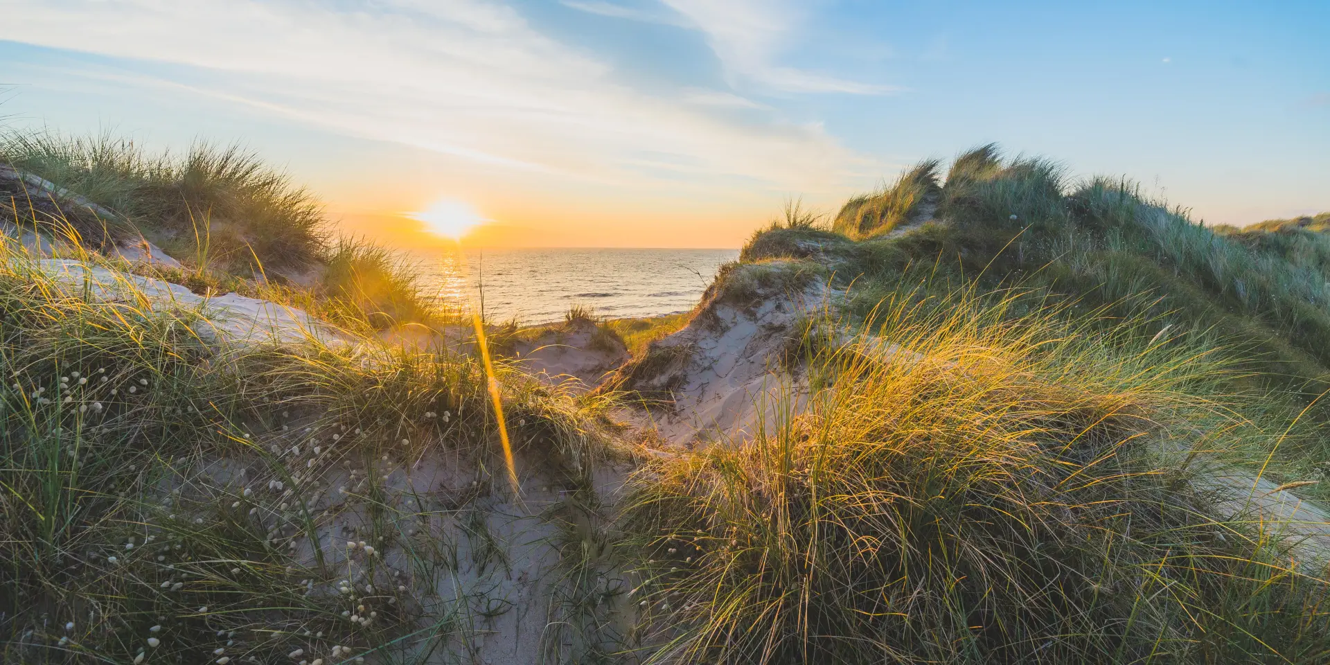 Couchant sur une dune herbeuse avec la mer en arrière-plan