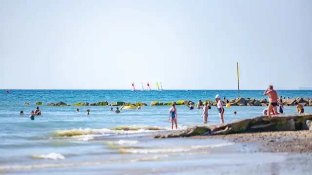 People swimming and relaxing on a rocky beach