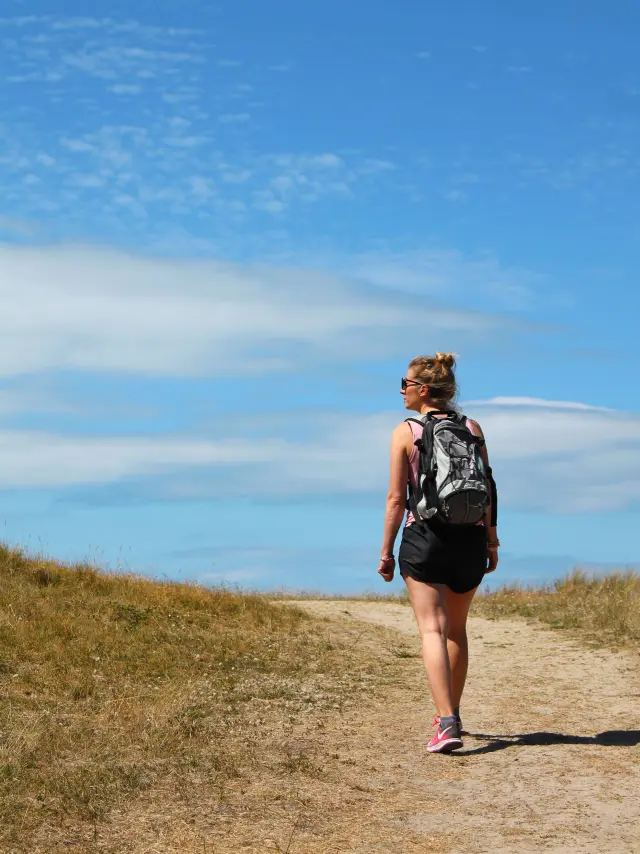 A person walking on a trail with a backpack