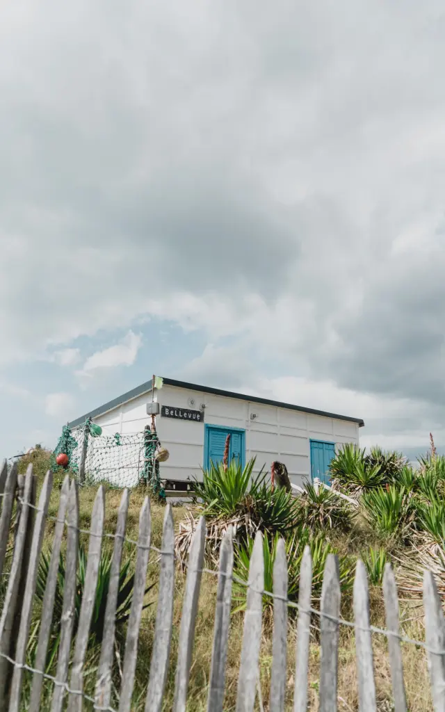 White beach house with a wooden fence