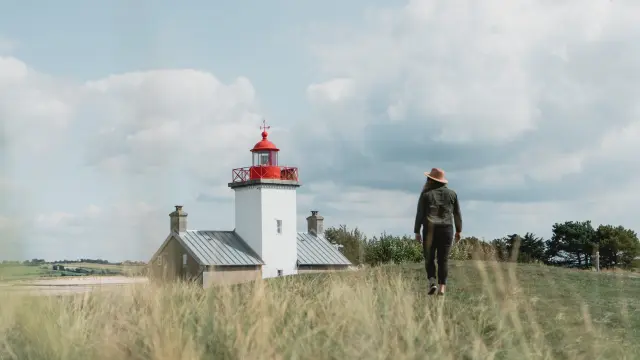 Personne marchant vers le phare de la pointe d'Agon