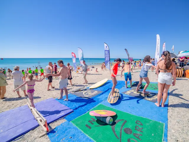 Menschen nehmen an einer Surfveranstaltung an einem sonnigen Strand teil